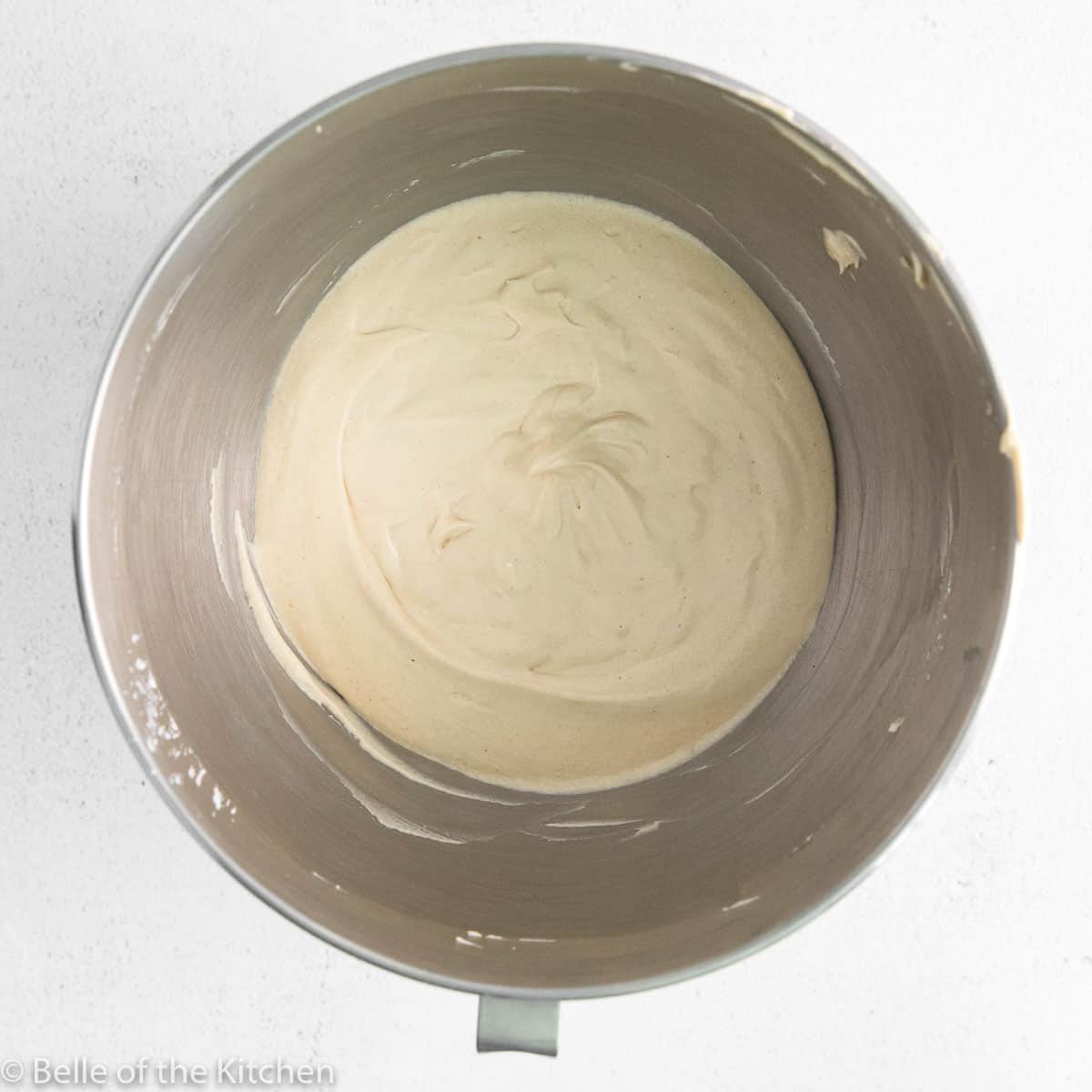a mixing bowl with whipped cream cheese inside.