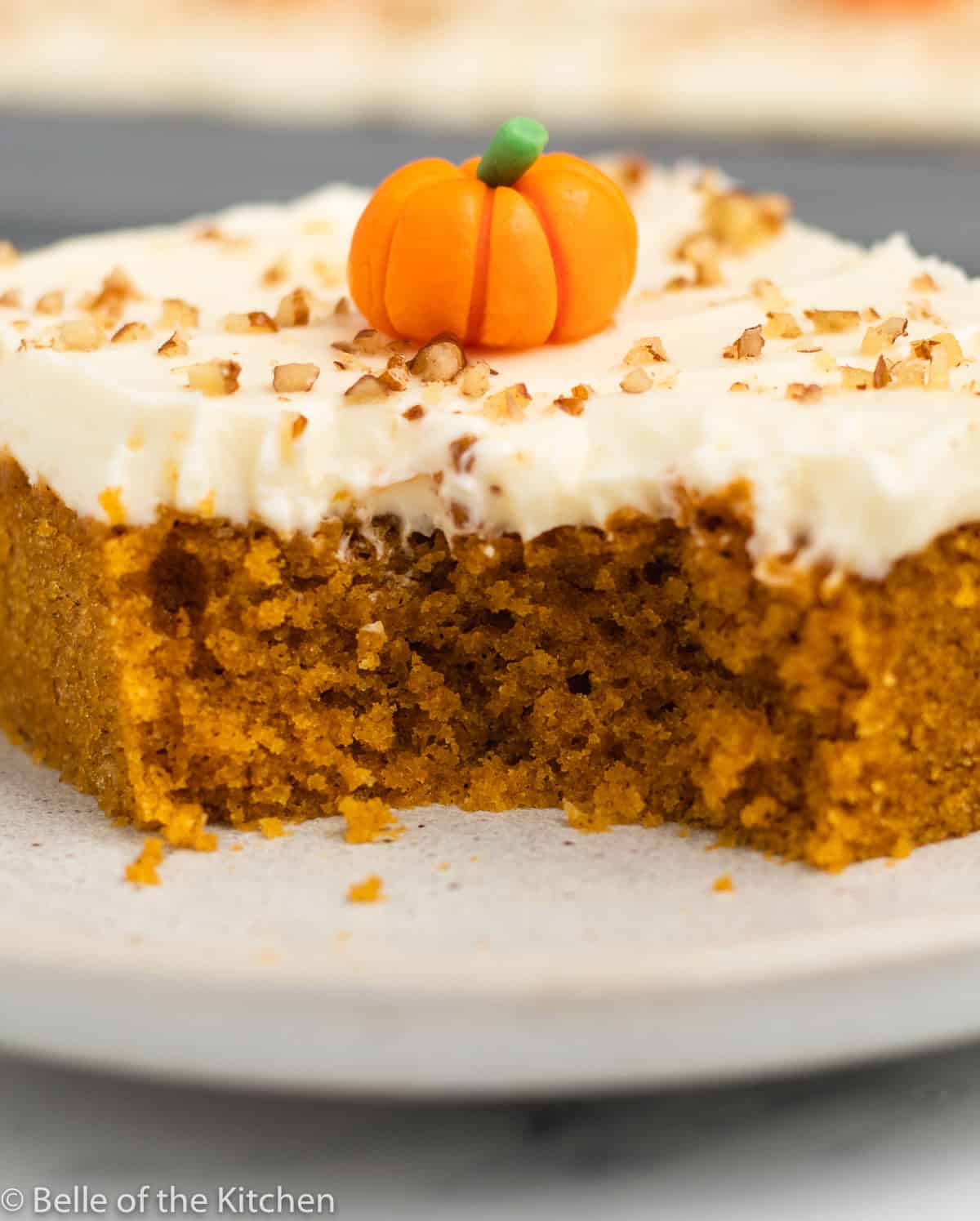 a slice of pumpkin cake on a plate with a bite taken out.
