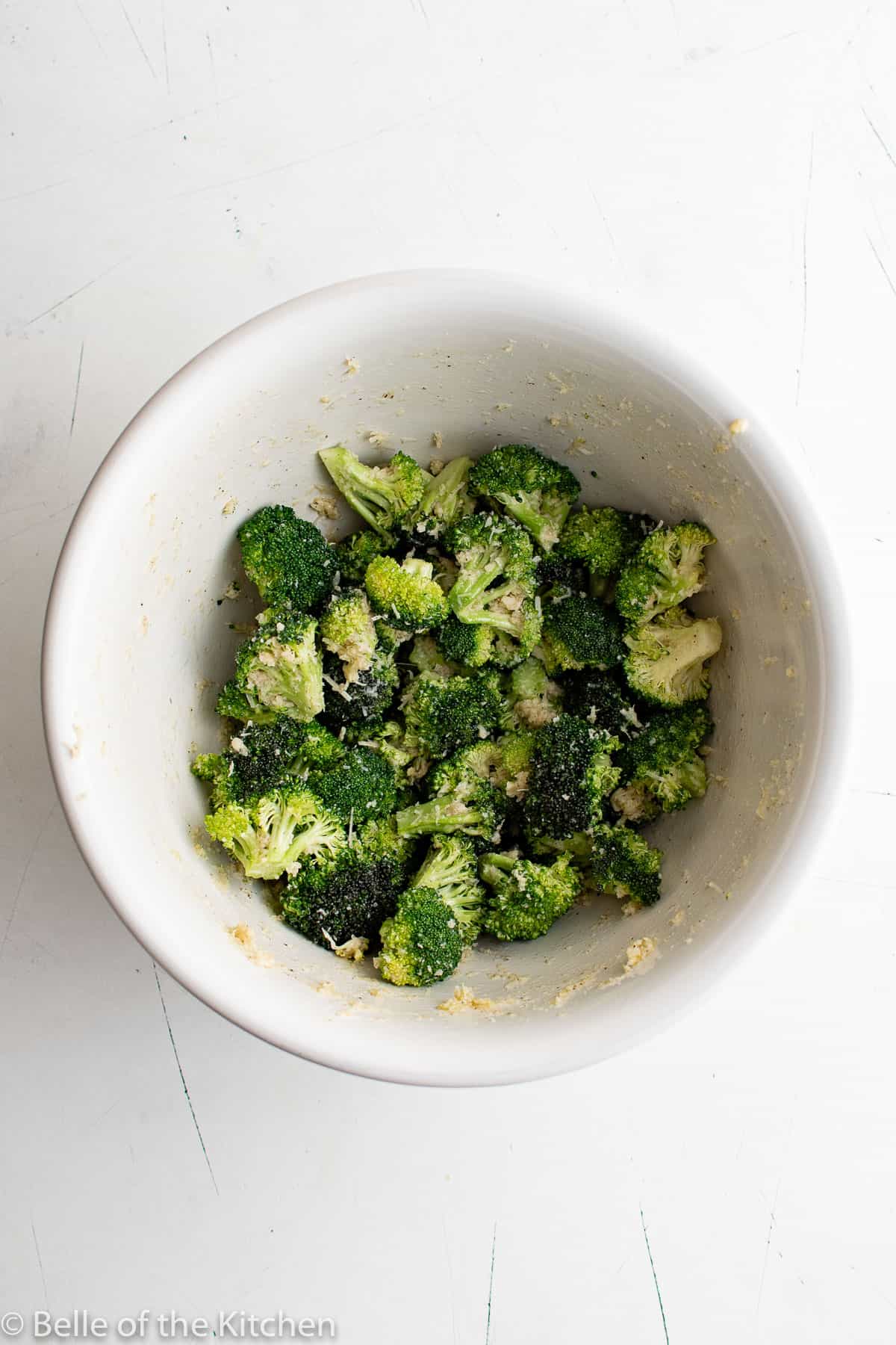 a white bowl of chopped broccoli.