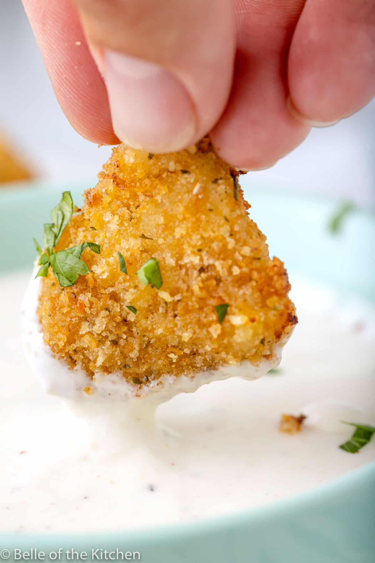 a chicken nugget dipping into ranch dressing.