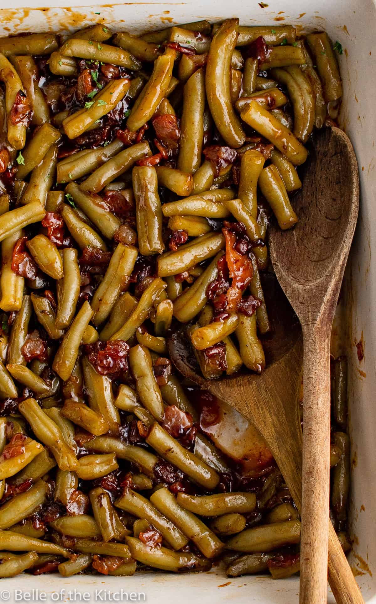 a white baking dish full of green beans and sauce.