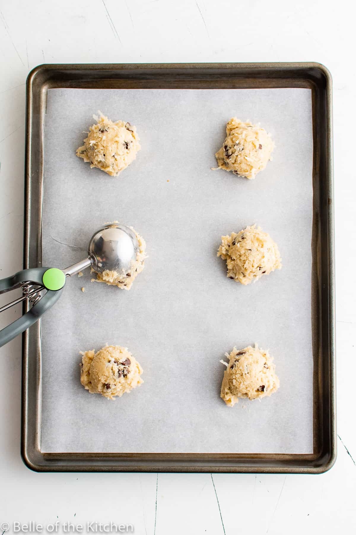 cookie dough being scooped onto a baking sheet.