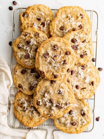 coconut chocolate chip cookies piled on a wire rack.