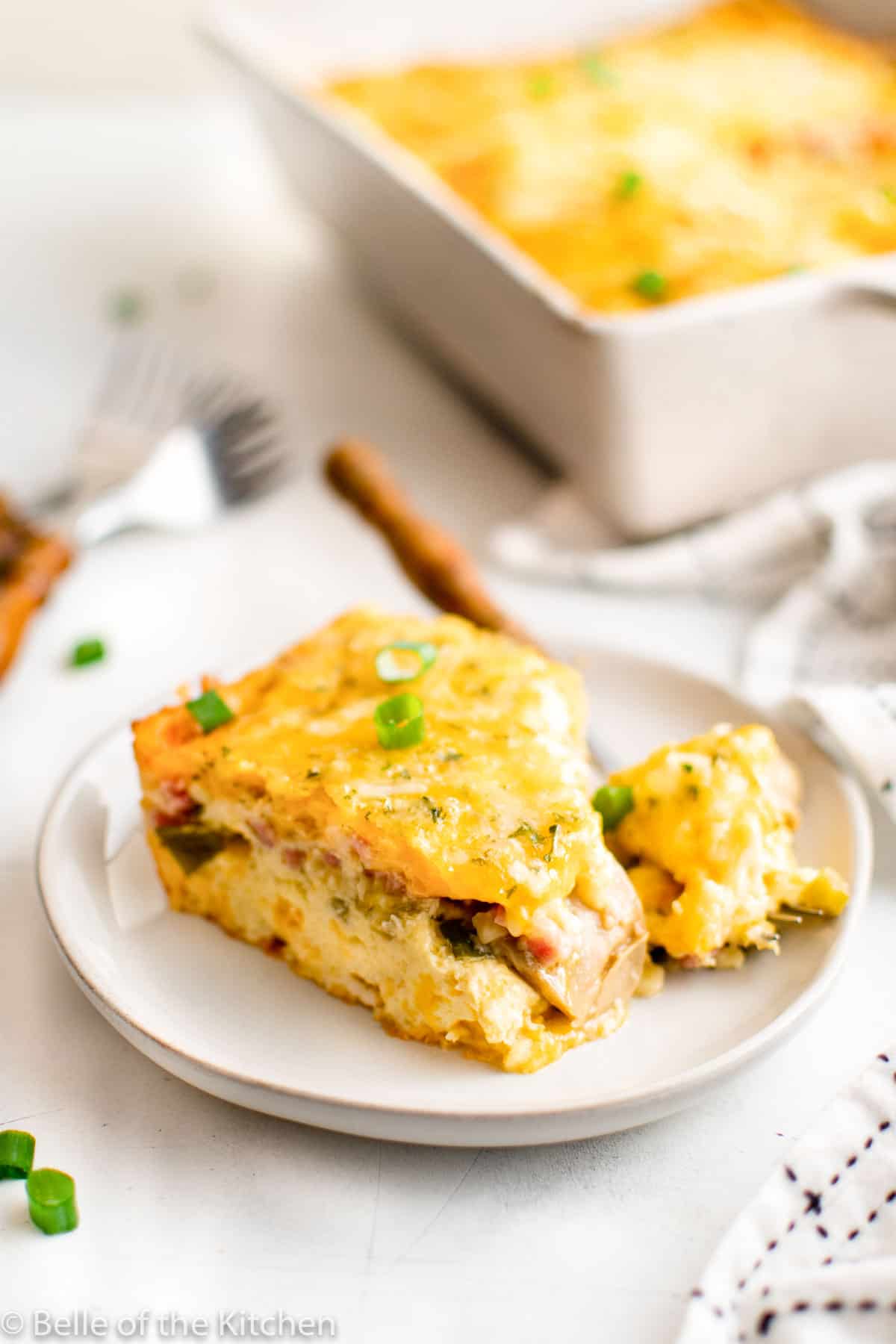 a slice of ham egg and cheese breakfast casserole on a plate.