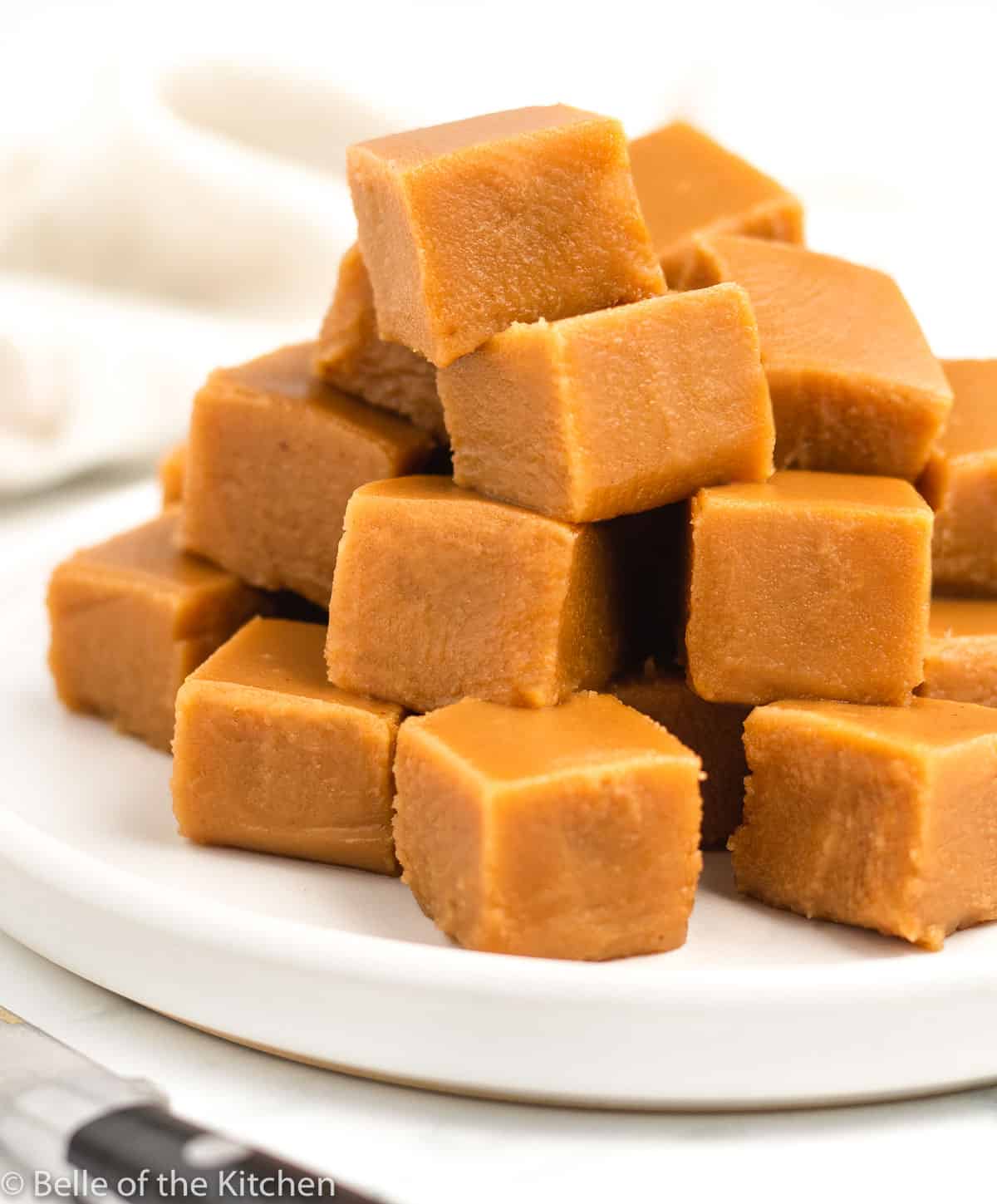 a plate stacked with pieces of peanut butter fudge.