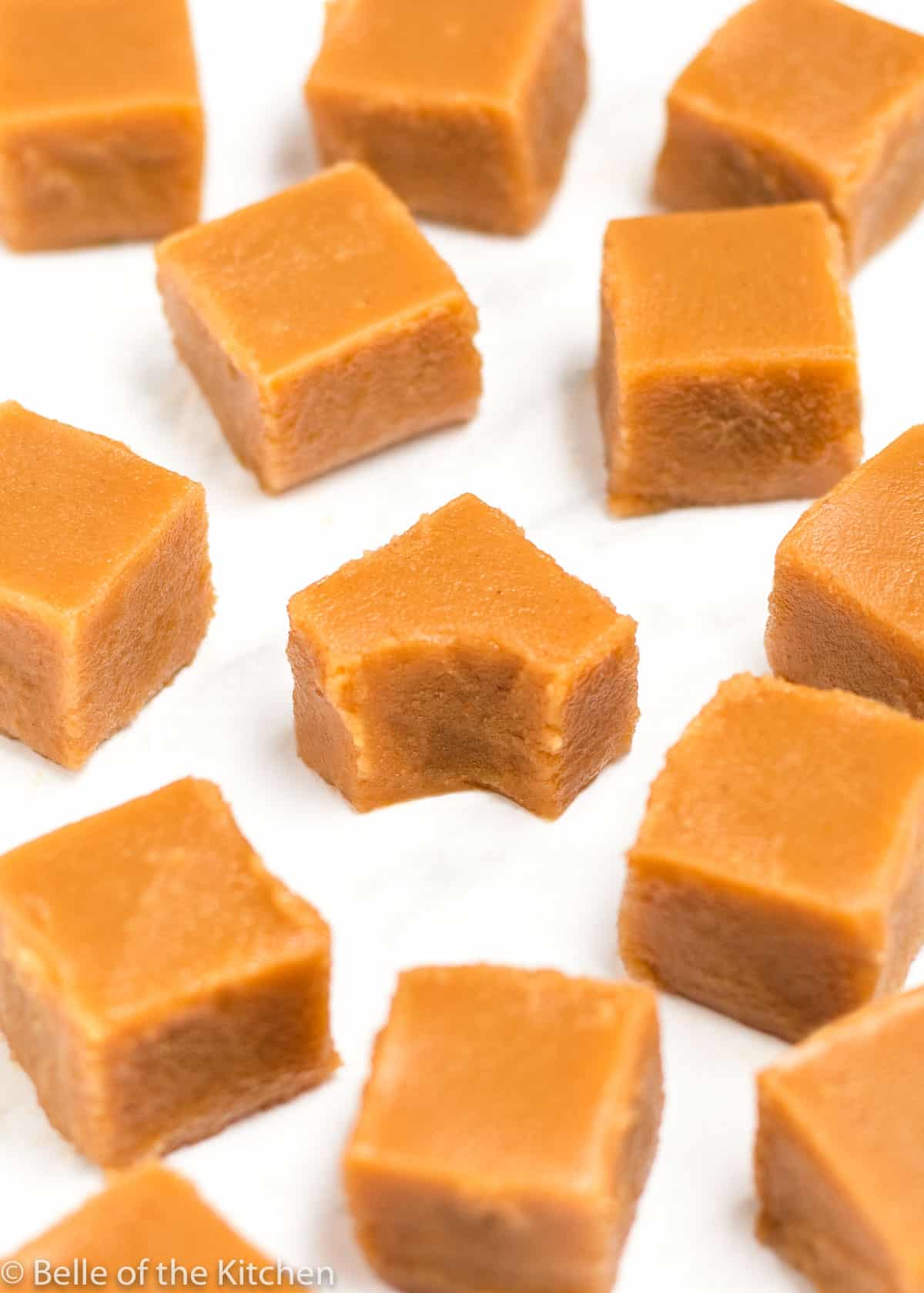 pieces of peanut butter fudge on a sheet pan with one that has a bite taken out.