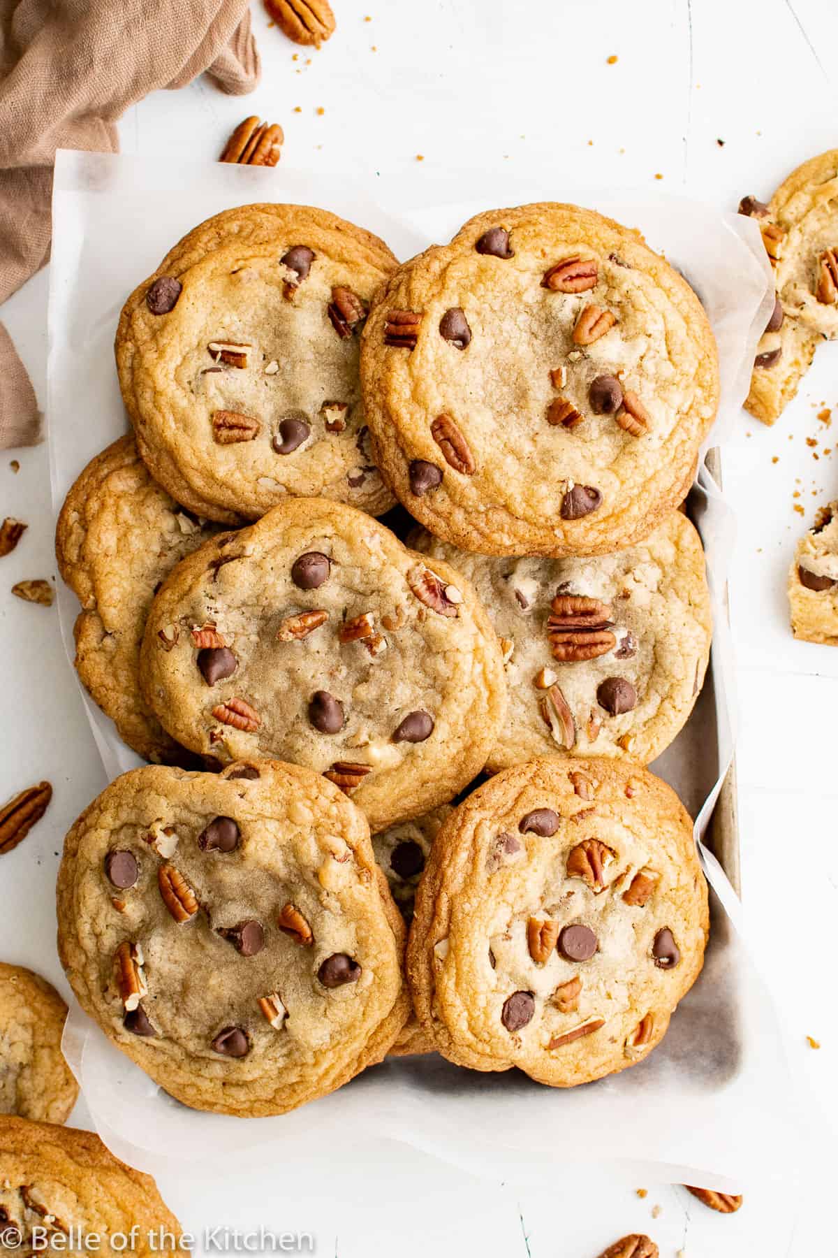 pecan chocolate chip cookies stacked on a wire rack.