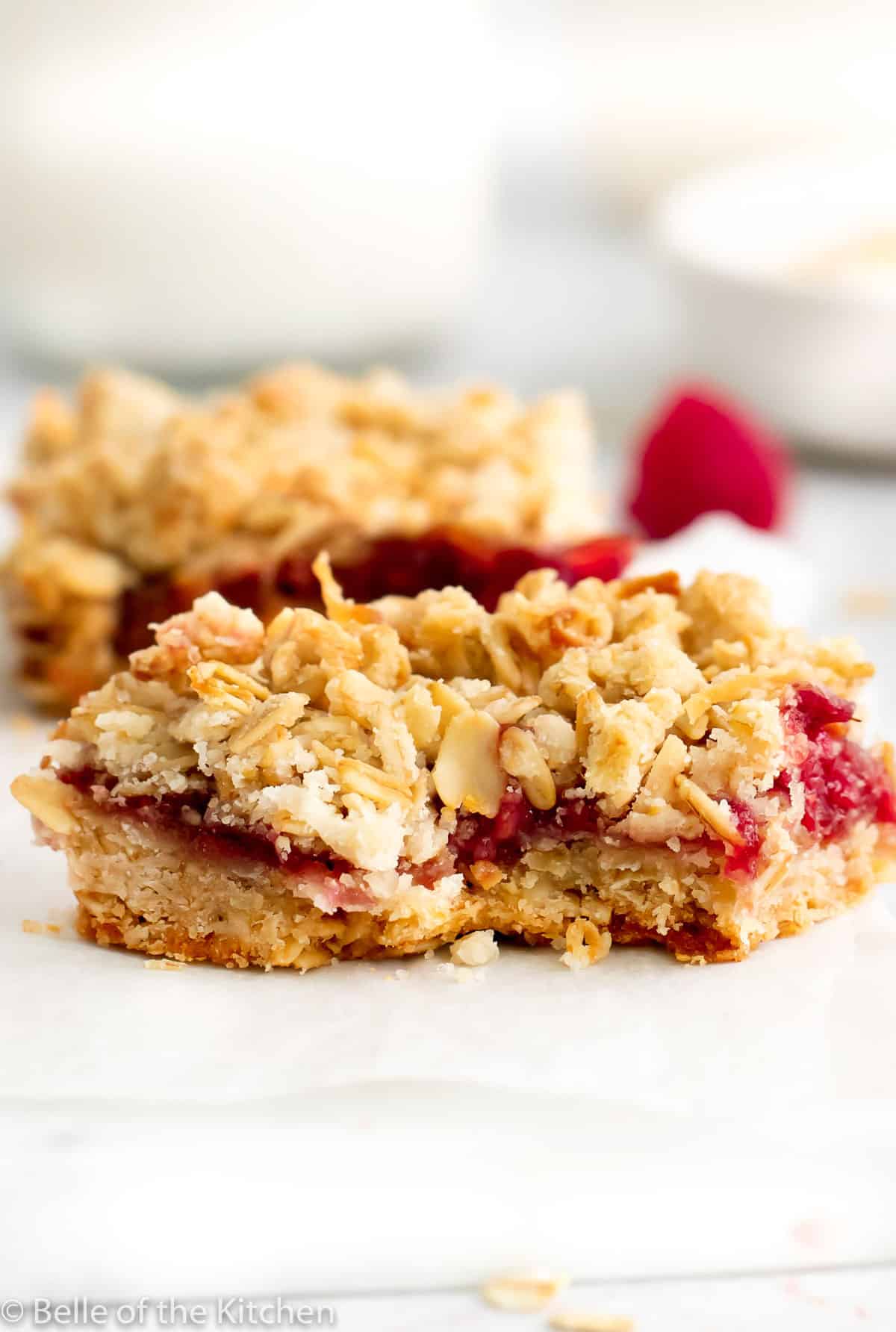 a raspberry oatmeal bar with a bite taken out.