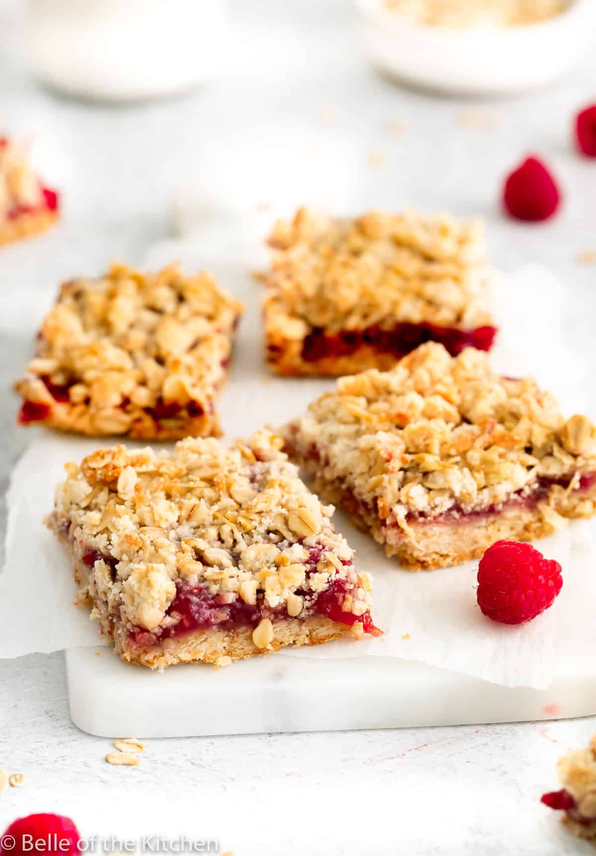 4 raspberry crumble bars on parchment paper.