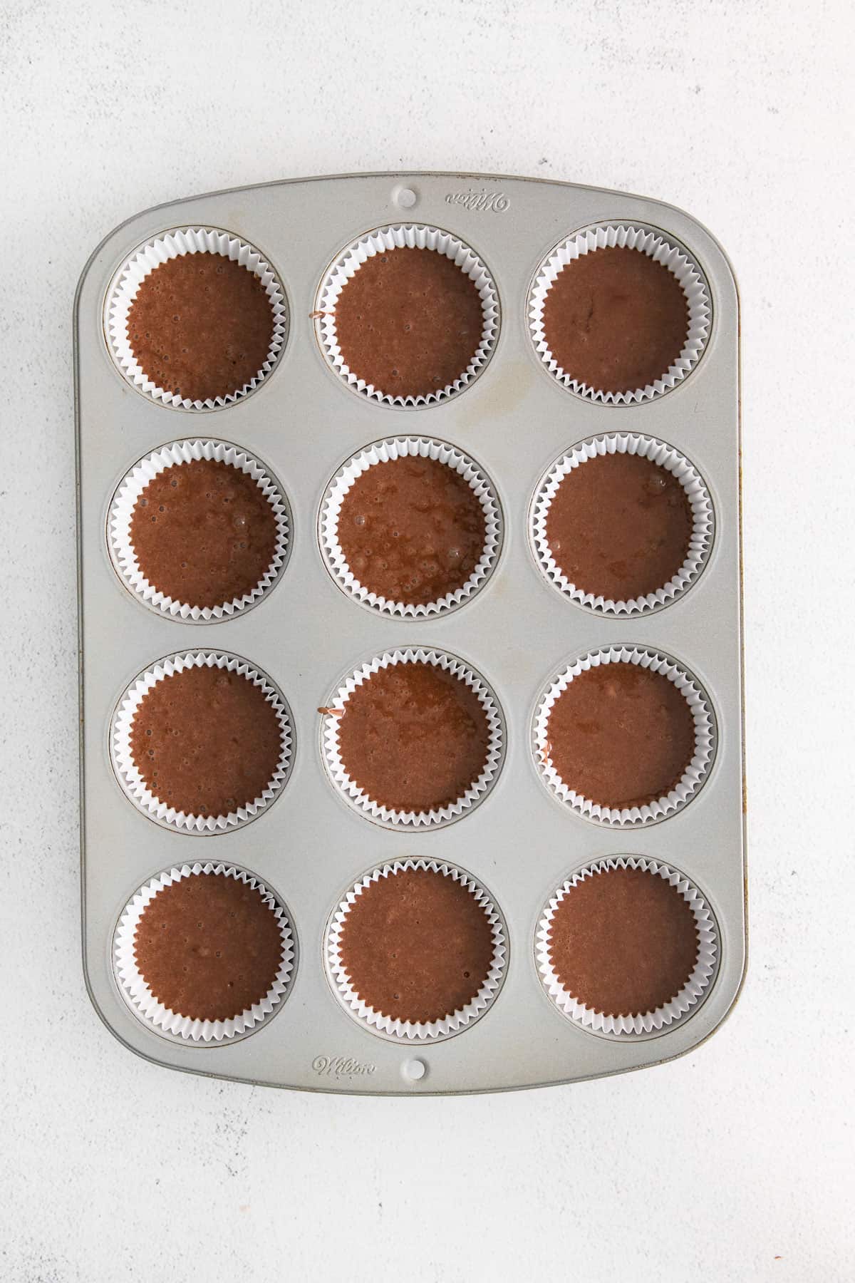 chocolate cake batter in a muffin tin.