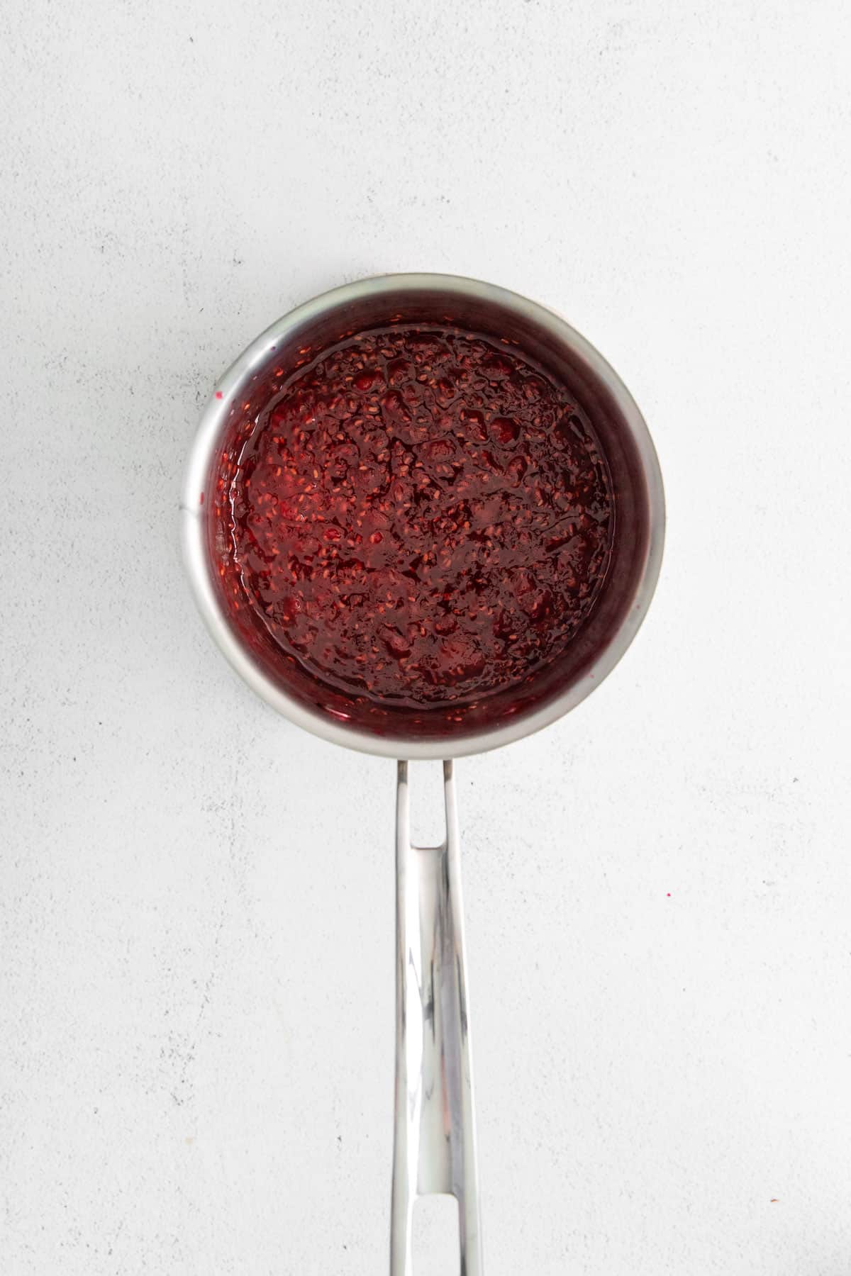a saucepan of raspberry jam.