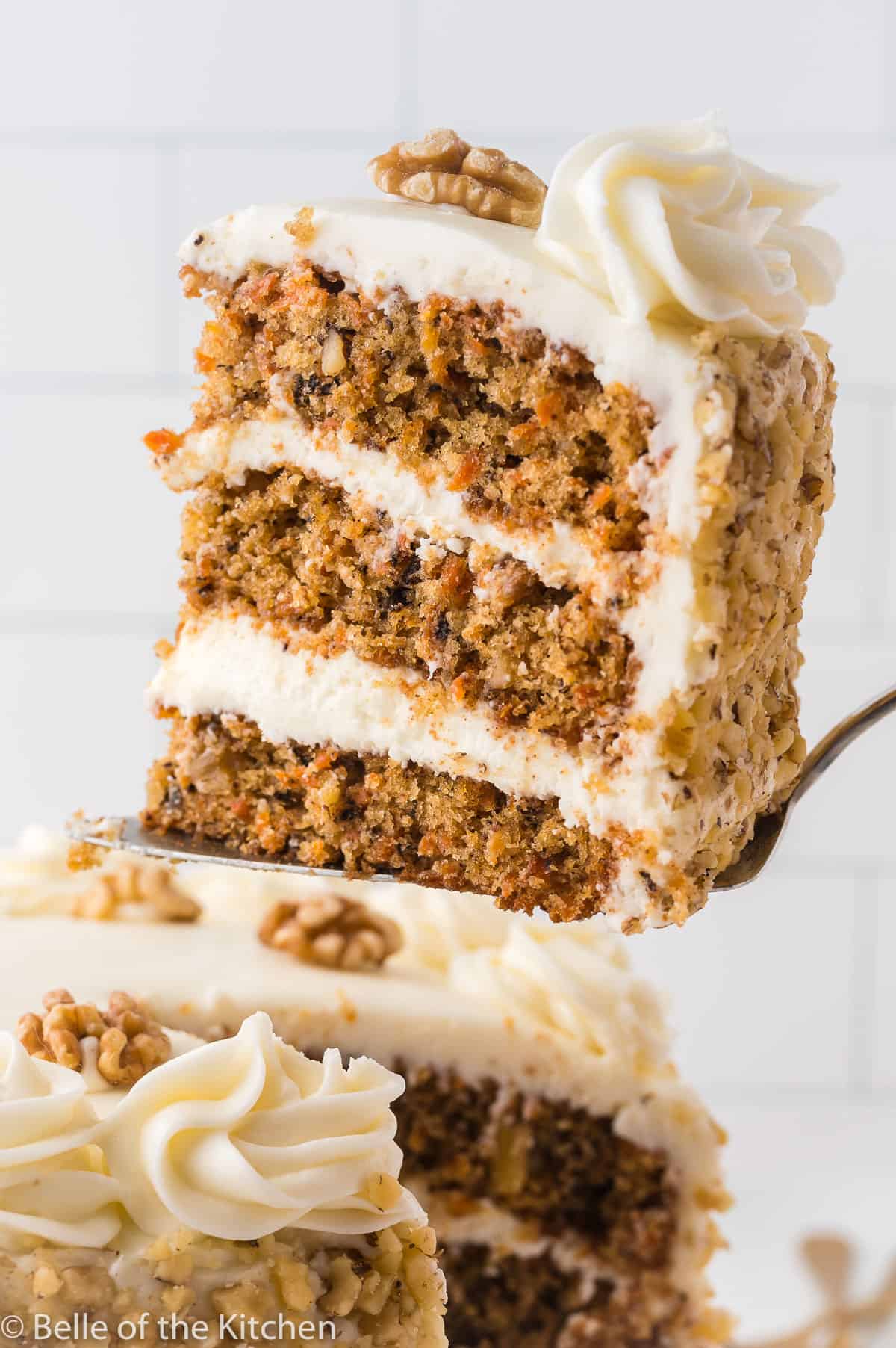 a cake server holding up a slice of carrot cake.