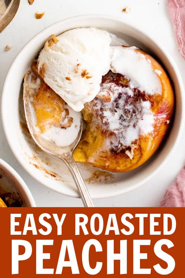 a roasted peach with ice cream in a white bowl being scooped out with a spoon.