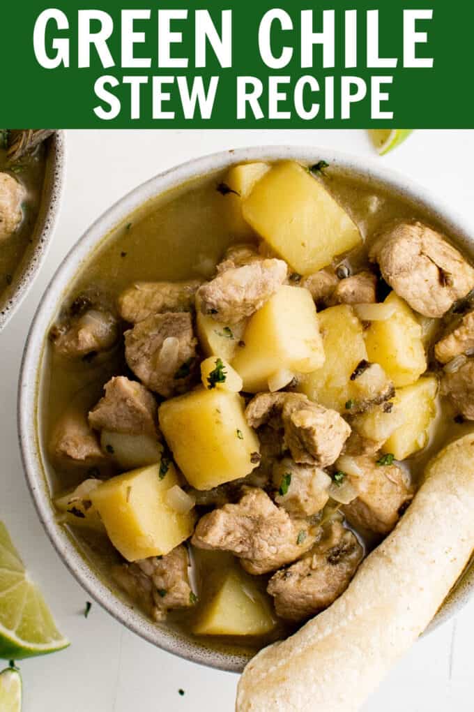 a bowl of soup with chunks of pork and potatoes with a tortilla.