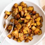 diced potatoes and spices in a white bowl.