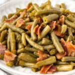 a plate full of green beans and bacon.