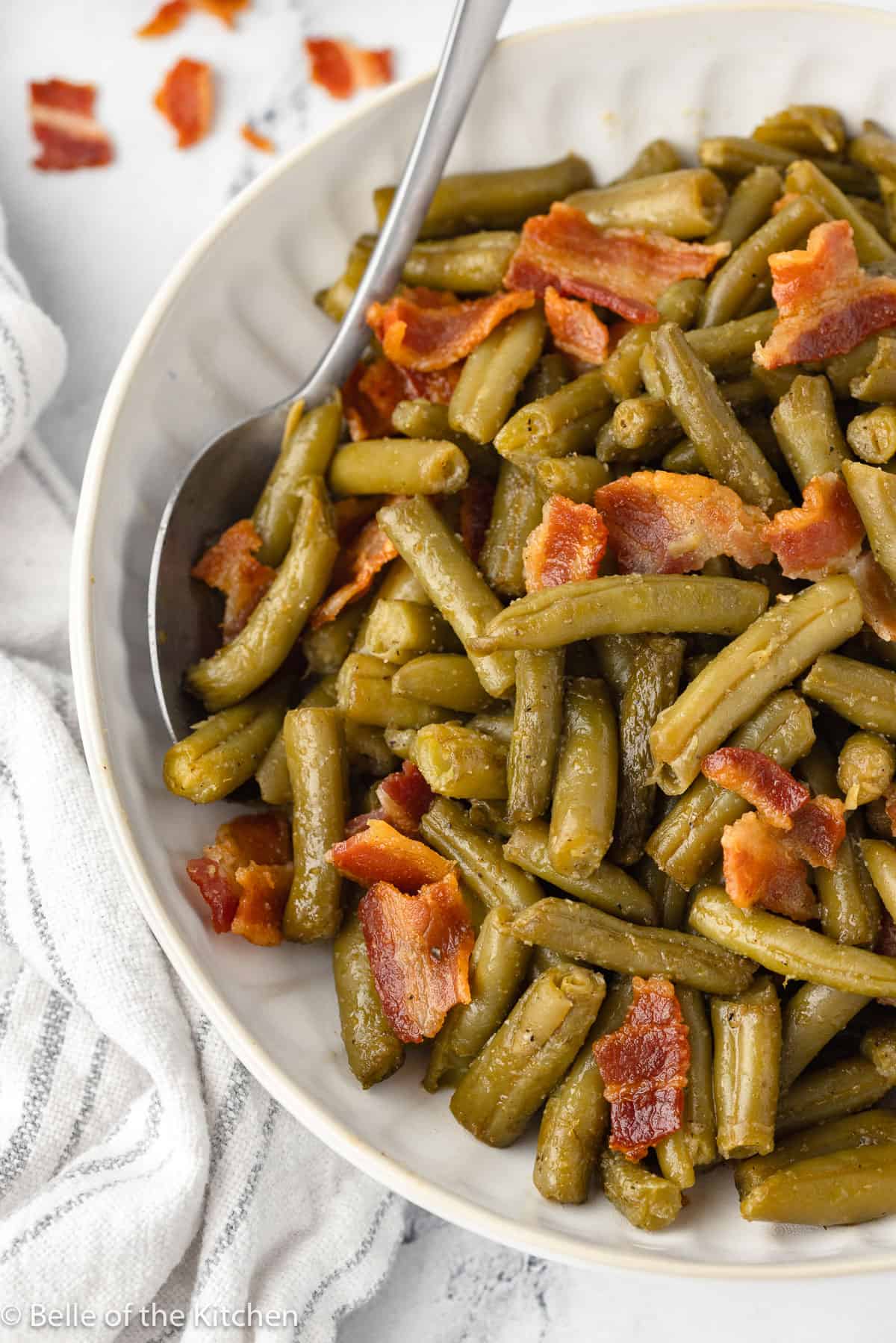 a bowl of green beans with a spoon.