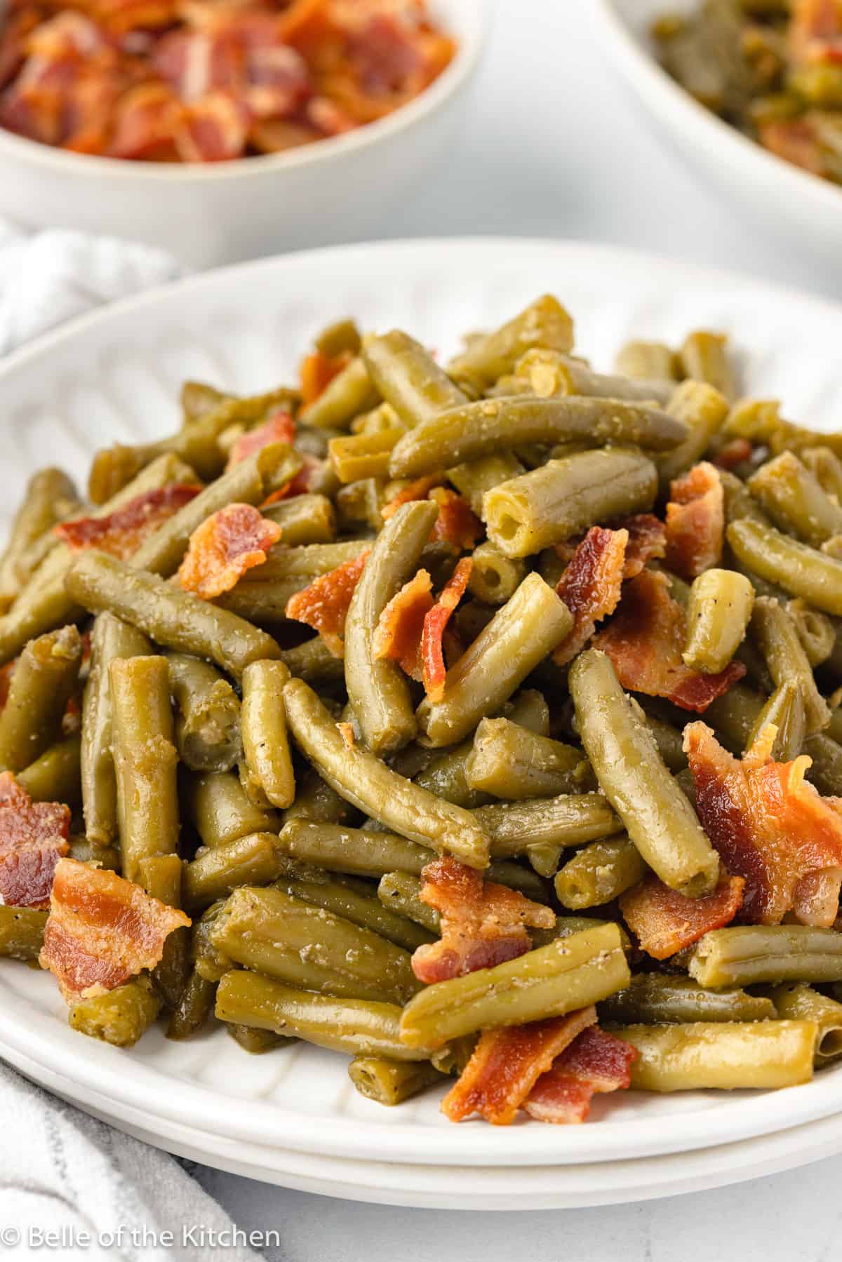 a plate full of green beans and bacon.