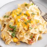 king ranch chicken casserole on a white plate with a fork next to it.