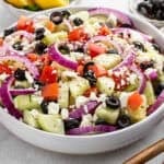 a white bowl full of cucumber tomato salad.