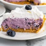 A slice of blueberry cream cheese pie on a white plate.