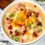 A bowl of potato soup topped with bacon and green onions.