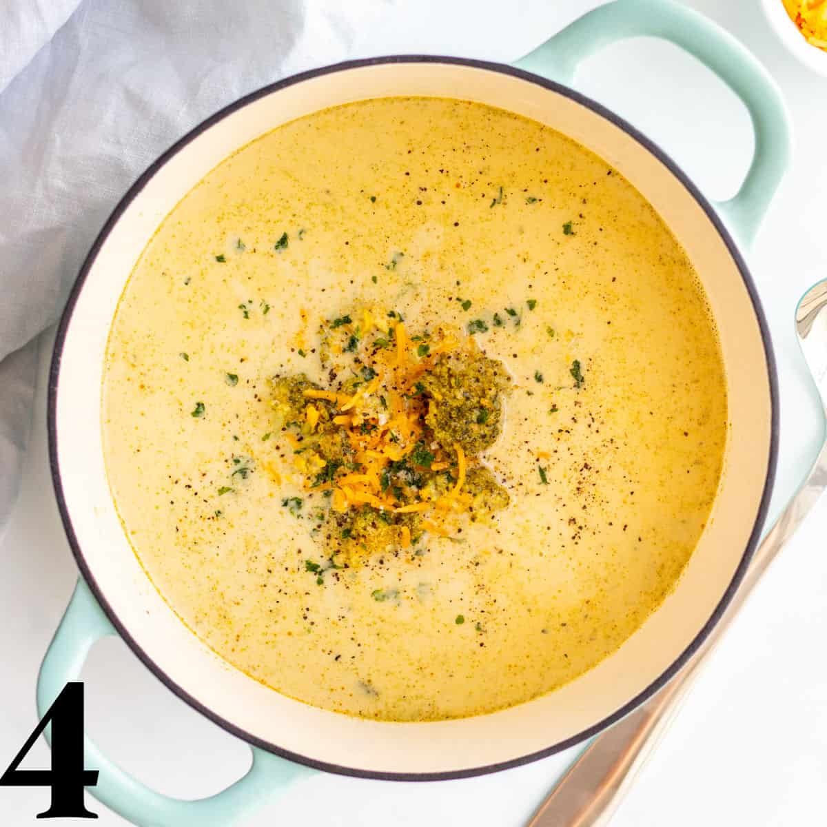 A dutch oven full of broccoli cheddar soup.