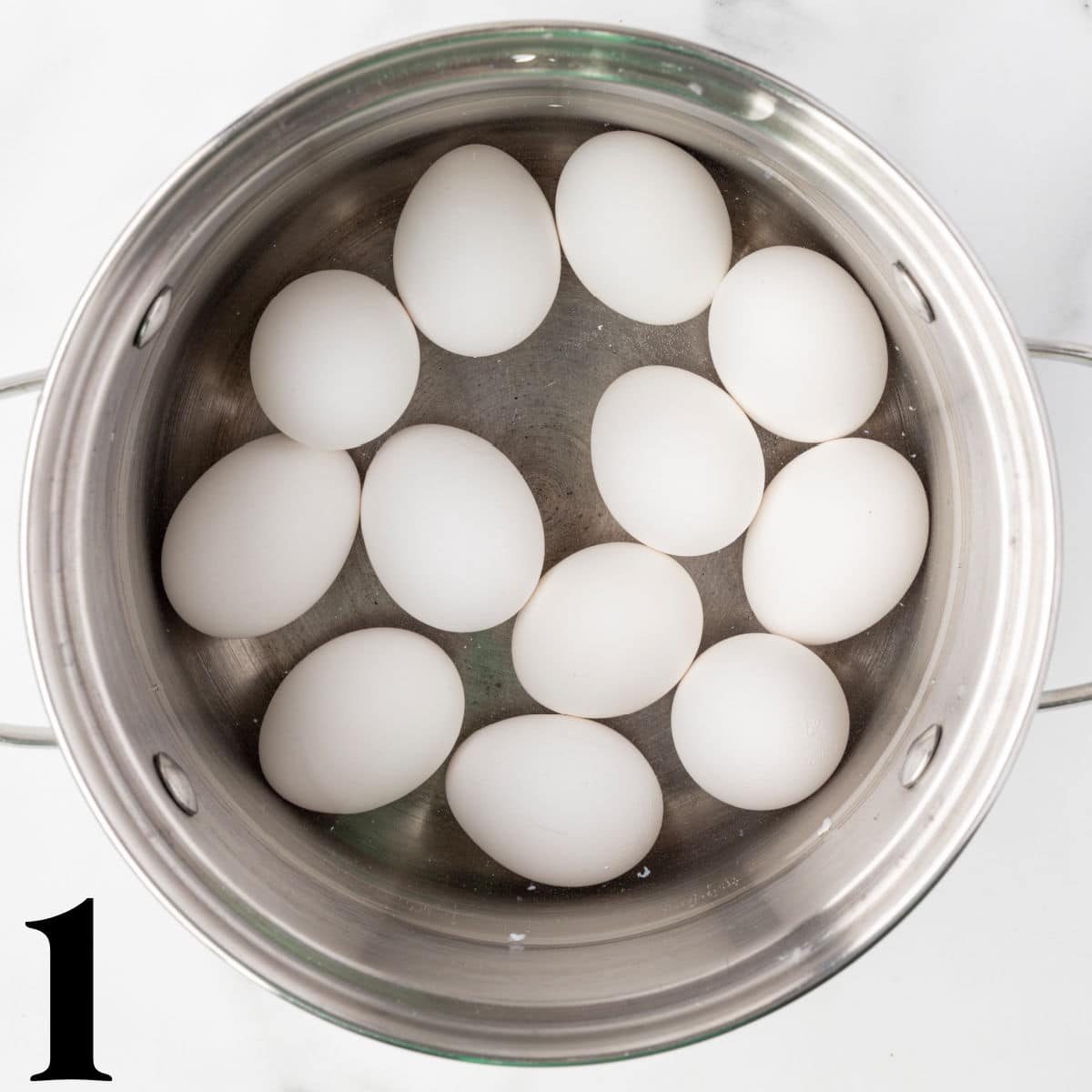 a saucepan full of eggs and water.