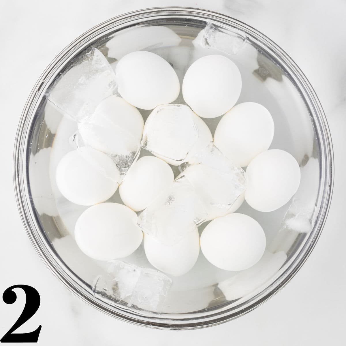 a bowl of water and ice filled with eggs.