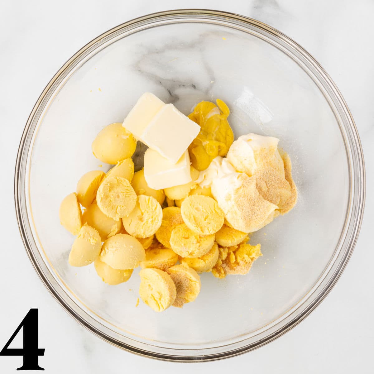 a bowl of cooked egg yolks with butter and mayo.