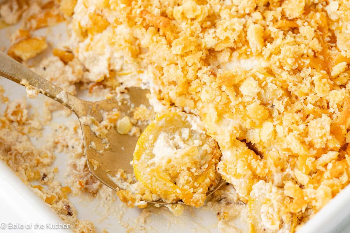 A close up shot of a spoon scooping up squash casserole.