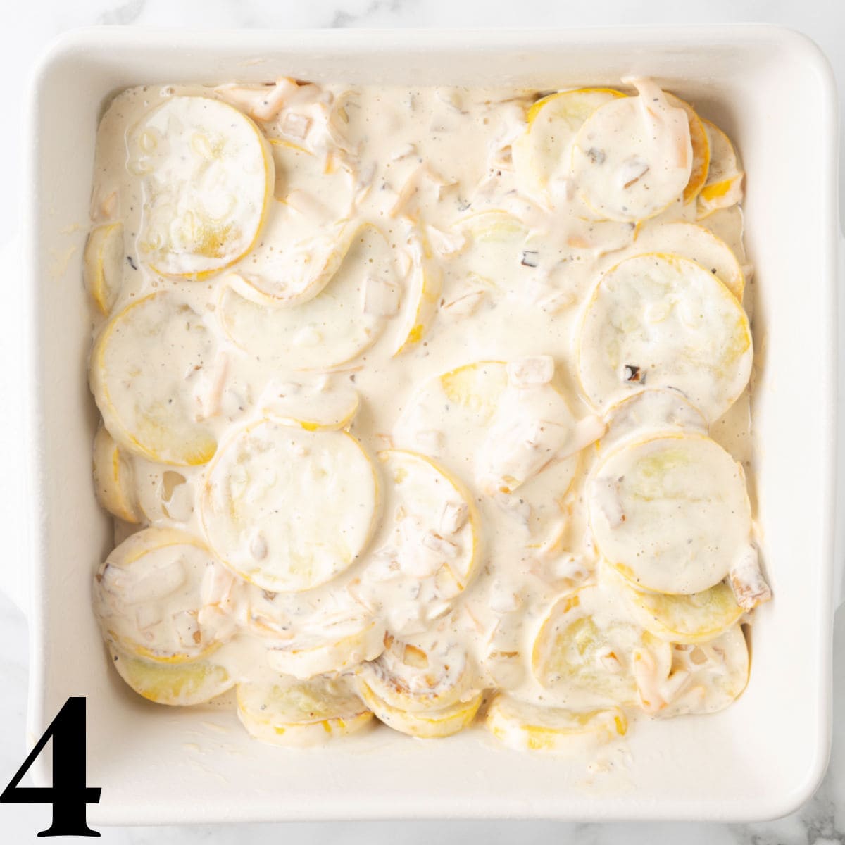 A casserole dish of squash with coated in a sauce.