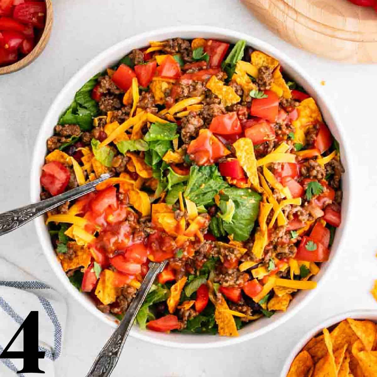 A white bowl of taco salad with Nacho Doritos.
