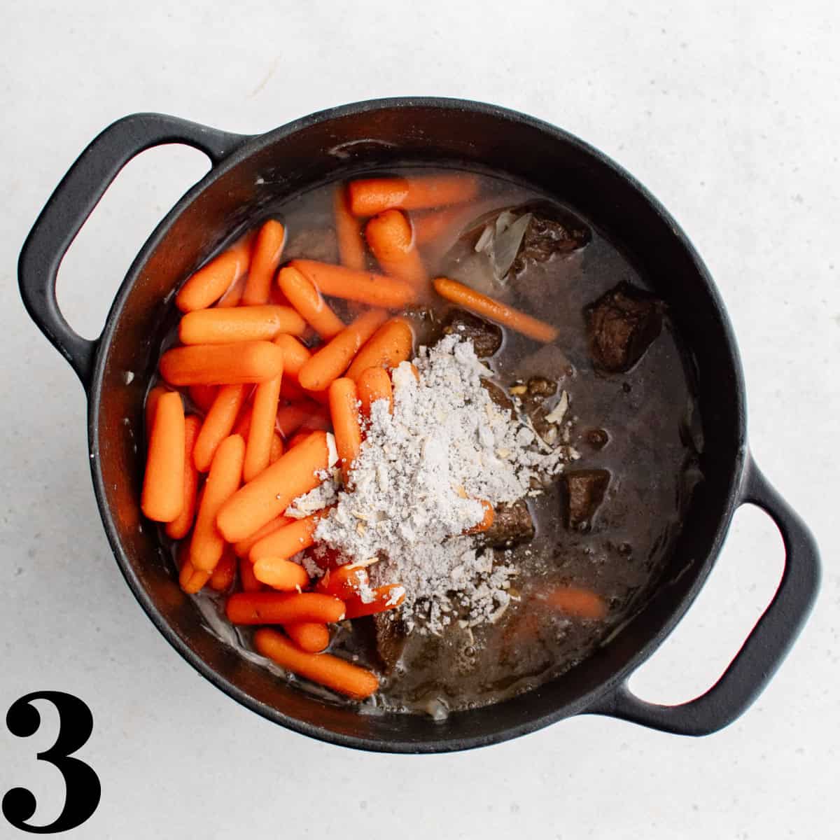 A large pot of carrots, beef, and seasonings.