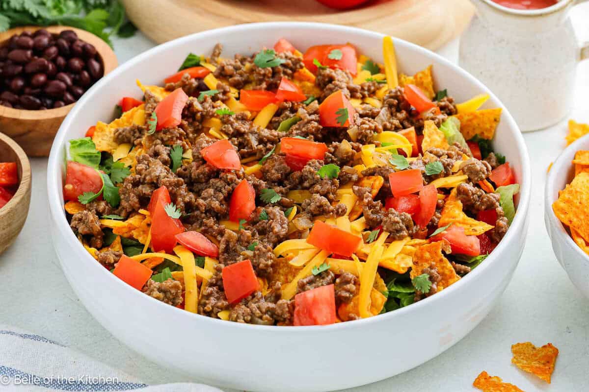A white bowl of taco salad with Nacho Doritos.