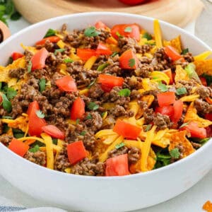A white bowl of taco salad with Nacho Doritos.