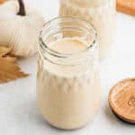 A decorative mason jar full of pumpkin coffee creamer.