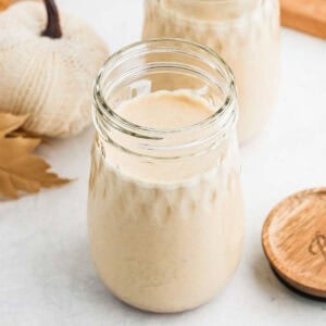 A decorative mason jar full of pumpkin coffee creamer.