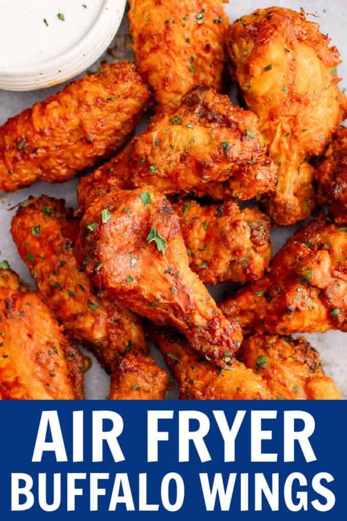 Buffalo wings on a tray with a bowl of ranch, carrots, and celery sticks.