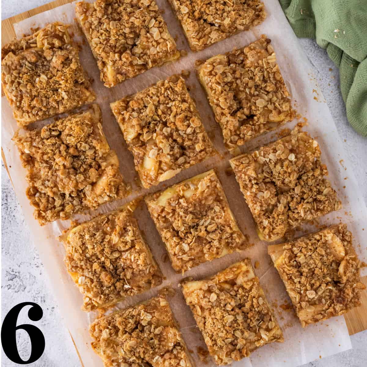 Sliced apple pie bars on a sheet of parchment paper.