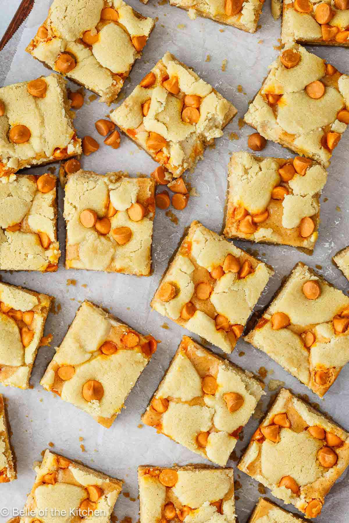 Pumpkin cheesecake bars cut into squares on a cookie sheet.