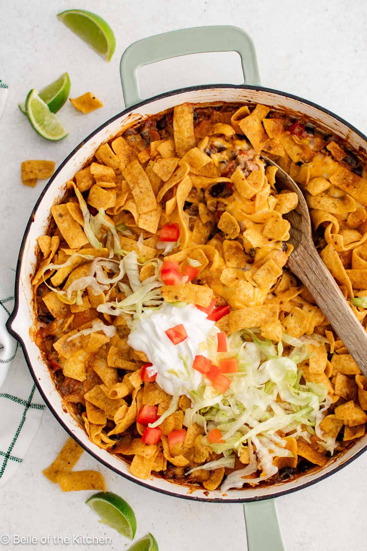 A skillet full of taco meat topped with Fritos.