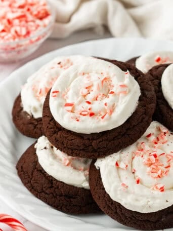 Chocolate cookies topped with frosting and crushed candy canes.