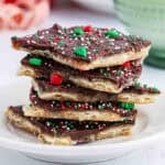 A stack of christmas crack (toffee) on a white plate.