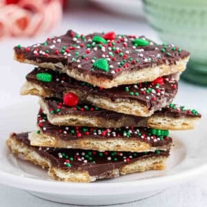 A stack of christmas crack (toffee) on a white plate.