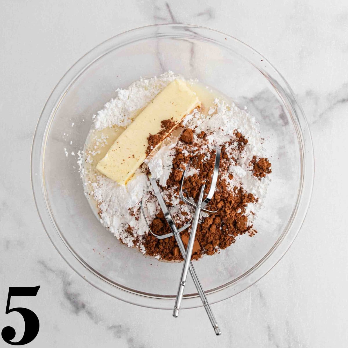 A glass bowl of frosting ingredients.