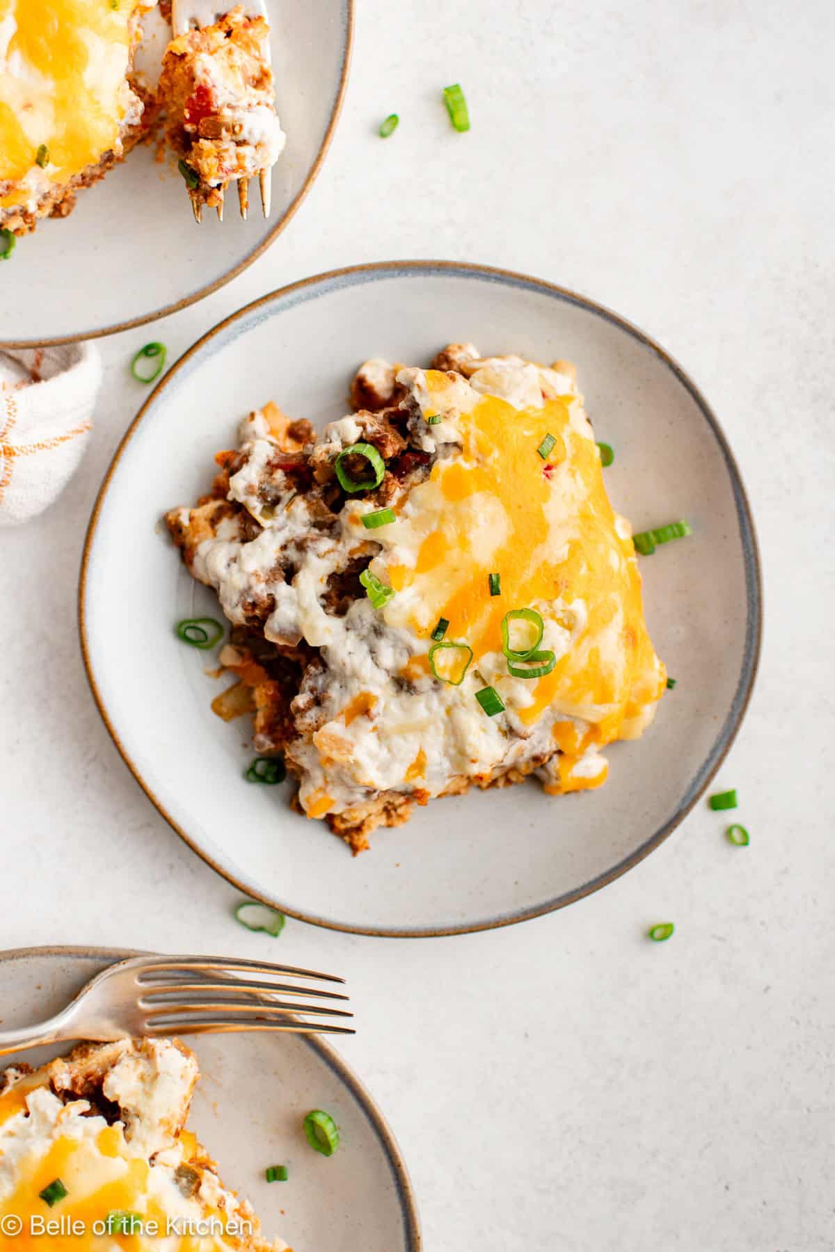 A white plate with a square piece of cowboy casserole on it with a fork.