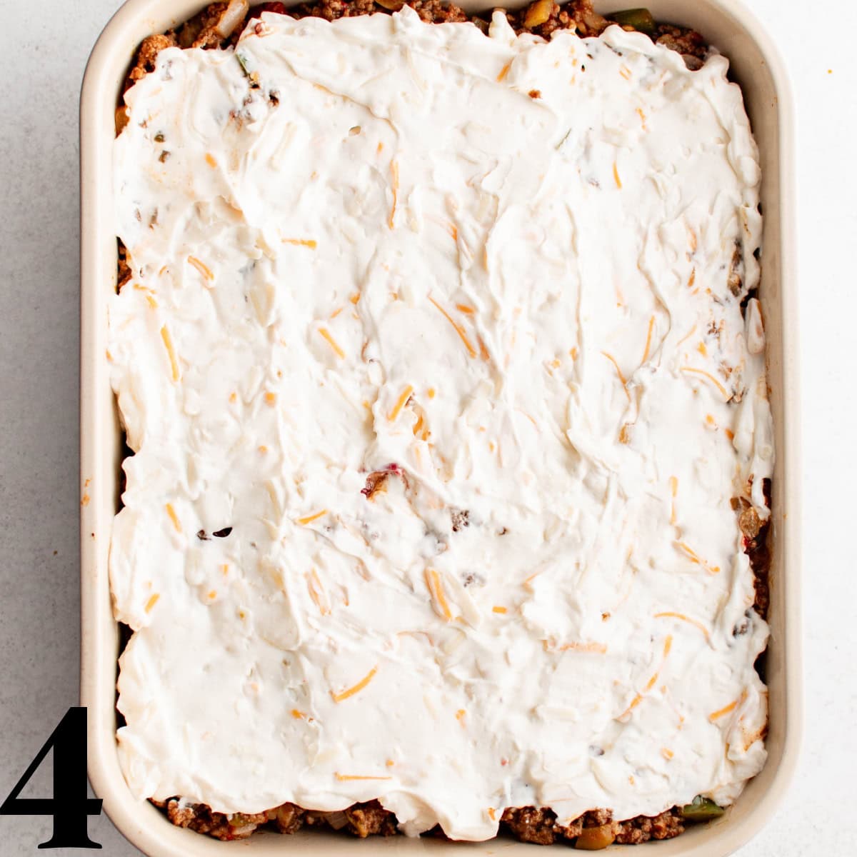 A casserole dish with a layer of mayo/cream cheese on top.
