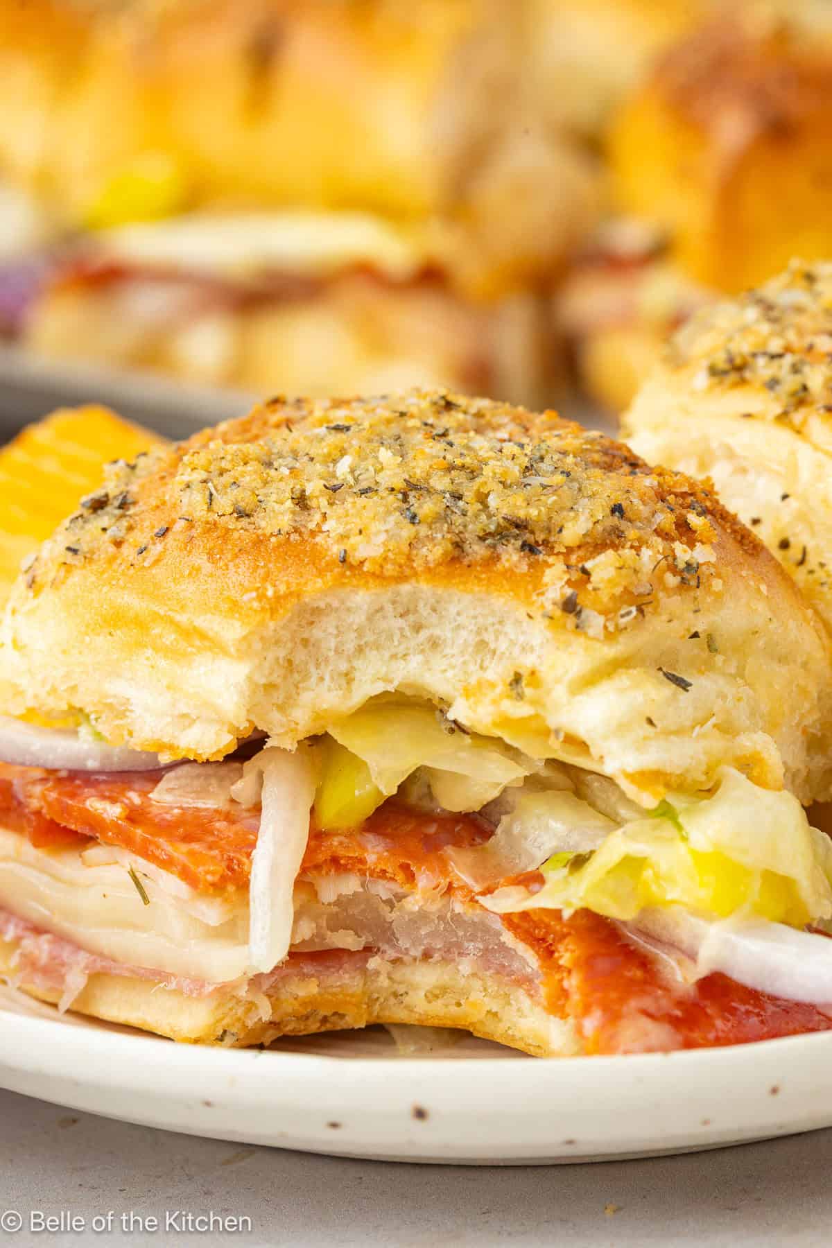 A close up of a slider sandwich with a bite taken out.