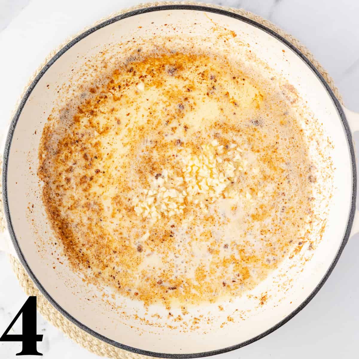 A skillet full of melted butter and garlic.